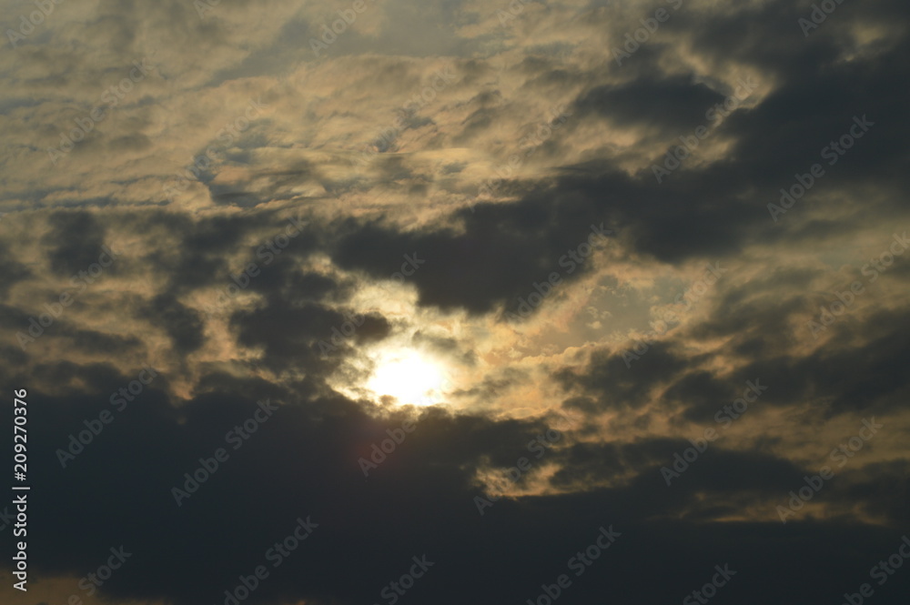 cloudy sky with clouds and translucent sun