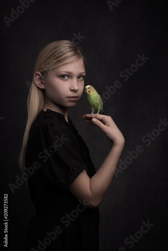 Studio portrait of girl holding bird achapornis photo