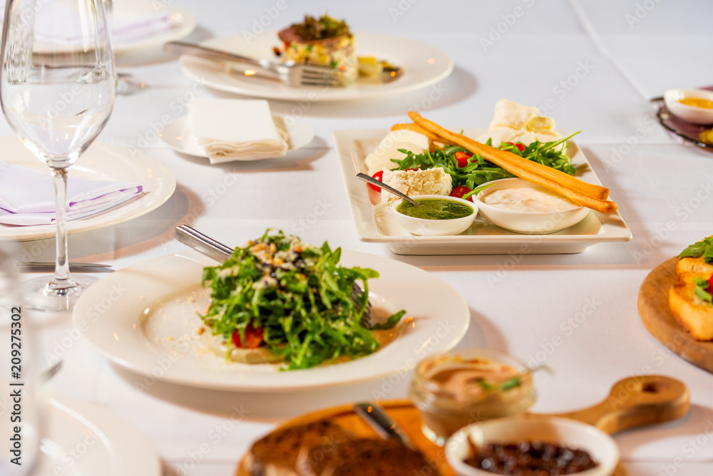 cheese sliced and salads on a beautiful white banquet table cheese sliced and salads on a beautiful white banquet table