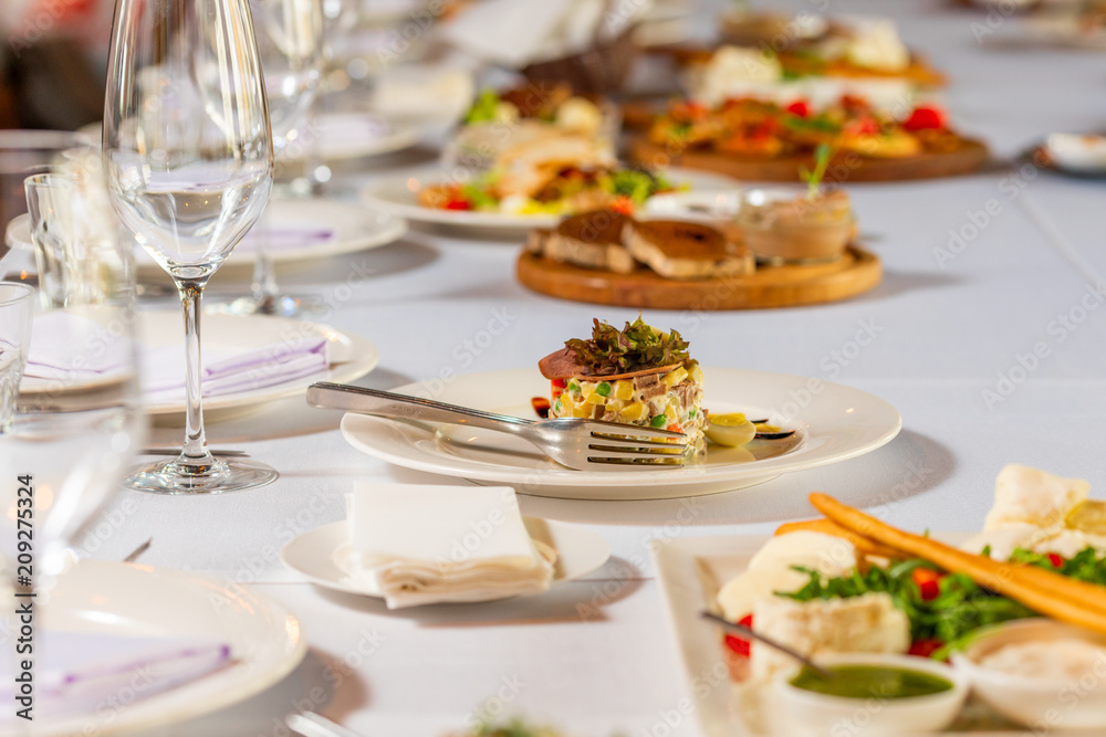 Salad with meat and peas and potatoes dressed with sauce on a beautiful banquet table Salad with meat and peas and potatoes dressed with sauce on a beautiful banquet table