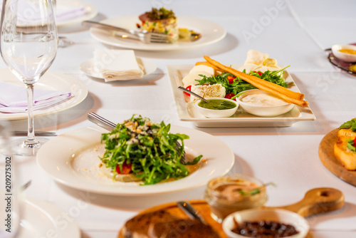 cheese sliced and salads on a beautiful white banquet table