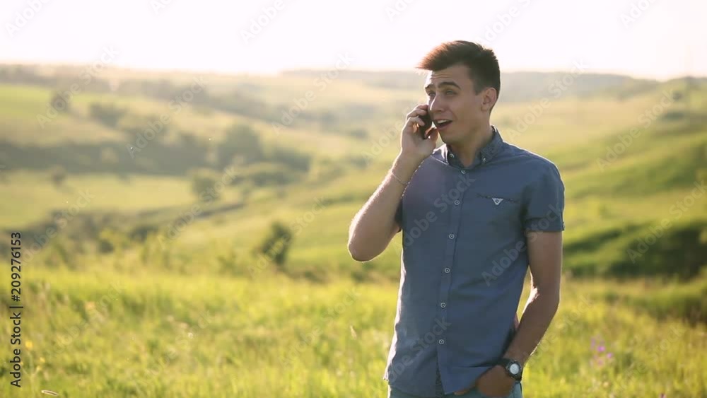 Young man uses a mobile phone outdoors. Attractive man talking on mobile phone, cheerful, laughing and smiling Young man uses a mobile phone outdoors. Attractive man talking on mobile phone, cheerful, laughing and smiling