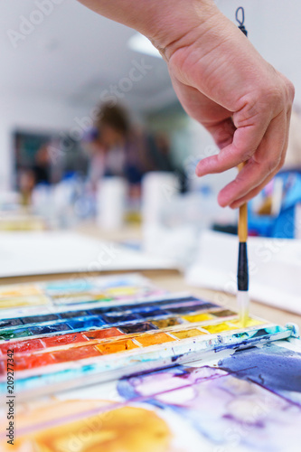 Artist makes the first brush strokes on a clean canvas while painting a watercolor painting.