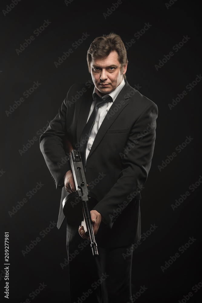 Fototapeta premium Handsome middle aged man gangster with Thompson machine gun