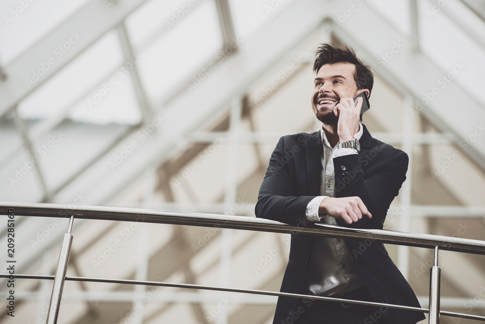 Businessman talking on phone near buildings. Businessman talking on phone near buildings.