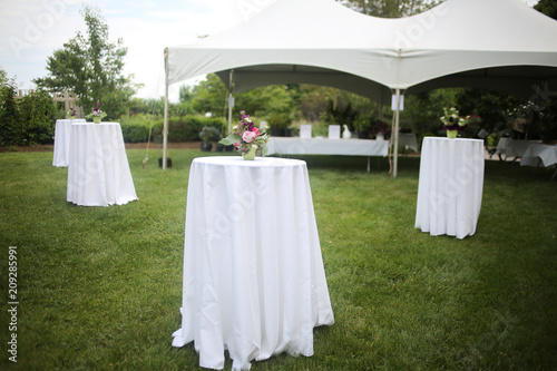 White Tents and High top Tables for an Outdoor Garden Event with Pink and Purple Centerpieces