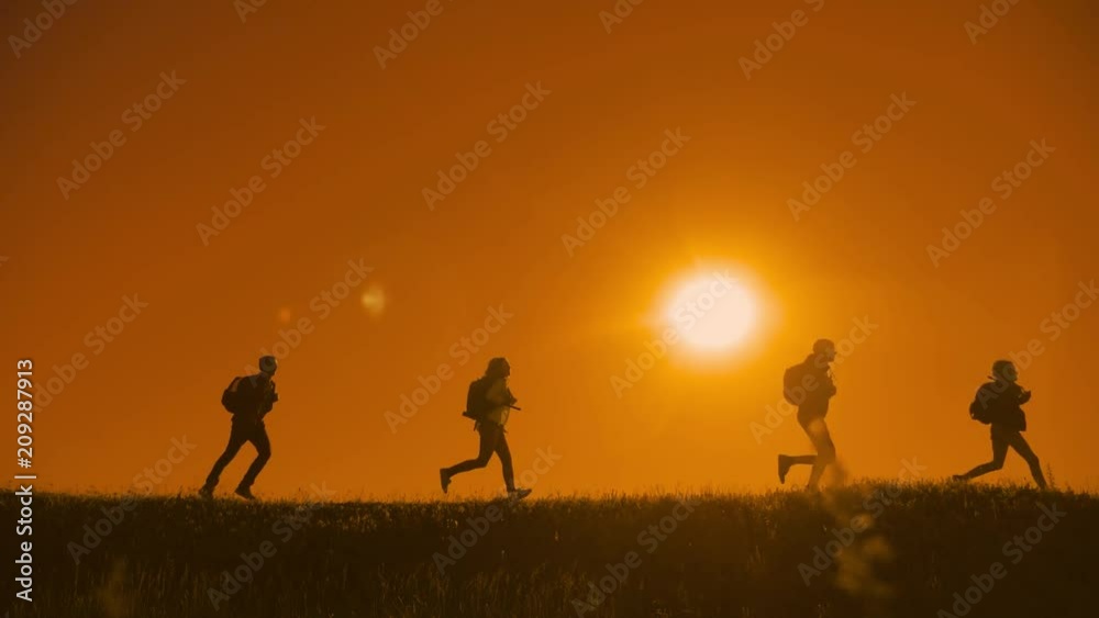 people hikers group happiness run and the dog silhouette of sunlight of tourists four people walking on top of a sunset silhouette mountain. slow motion running video tourists hiker people group go people hikers group happiness run and the dog silhouette of sunlight of tourists four people walking on top of a sunset silhouette mountain. slow motion running video tourists hiker people group go