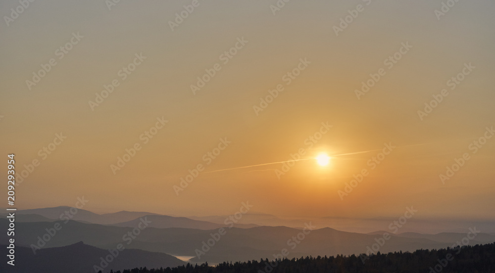 Dawn and sun over mountain range in summer