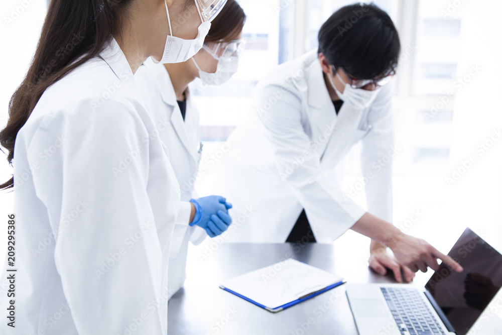 パソコンをみて意見を述べあう研究員 パソコンをみて意見を述べあう研究員