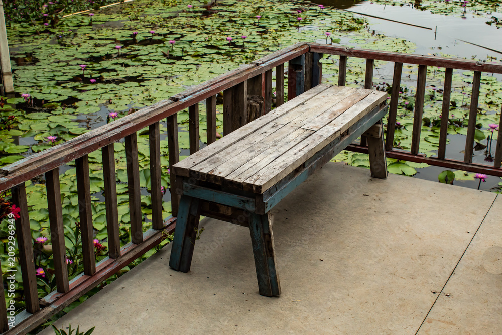 Wooden chair on the terrace along the lotus pond.