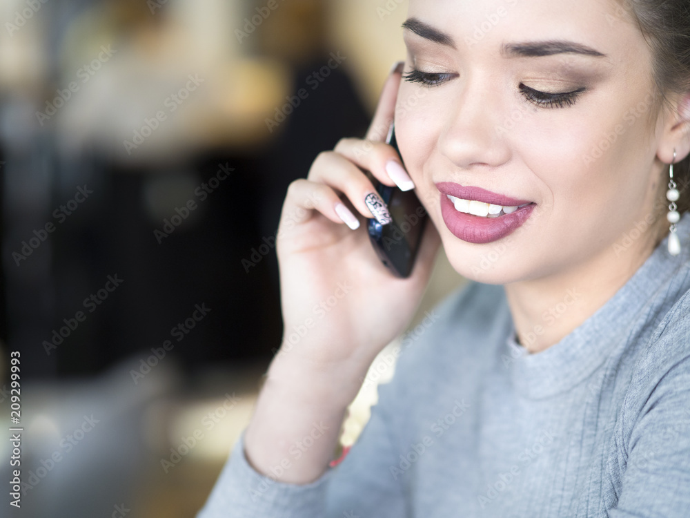 Portrait of a smiling woman talking on her mobile phone, looking away. Portrait of a smiling woman talking on her mobile phone, looking away.