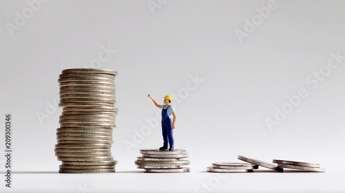 The concept of a social gap between labor and wages. The stack of coins with miniature people.