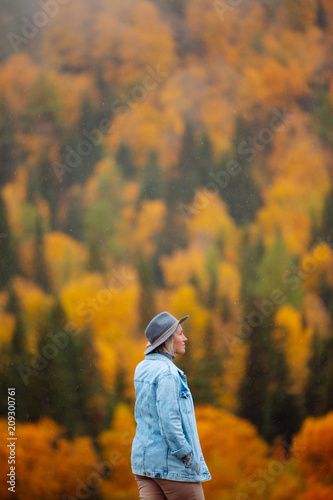 Beautiful young woman on a walk in autumn forest. Landscape in autumn.  © glazunoff