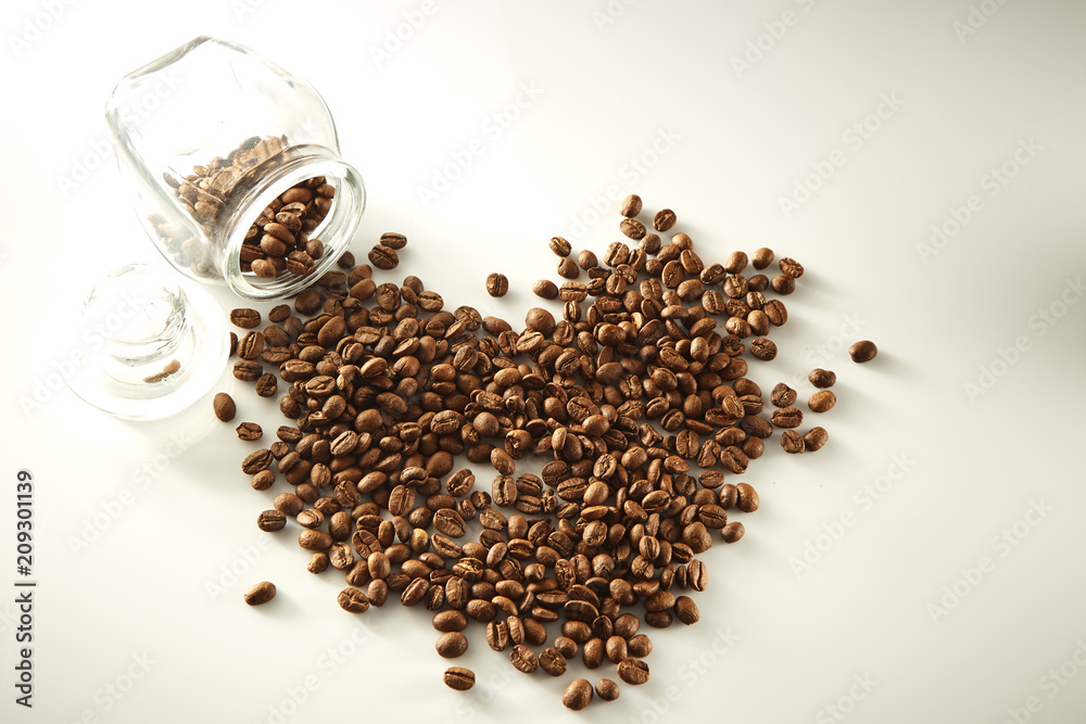 roasted coffee beans poured from clear glass roasted coffee beans poured from clear glass