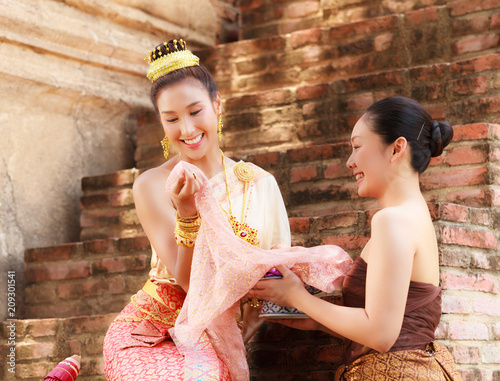 Asian noble beauty with maid dressed in traditional clothes shopping in old retro historical period theme photo