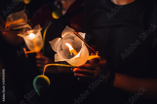 Buddhist praying with incense sticks, lotus flower and candles on holy religion day of Vesak at night
