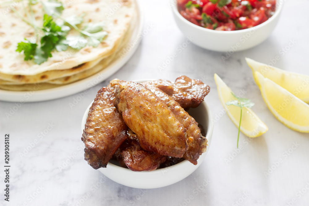 Homemade delicious food of tortillas, salsa and fried wings.