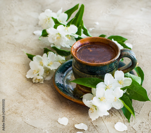 a cup of coffee on gray background, good morning coffee with white jasmine flowers 