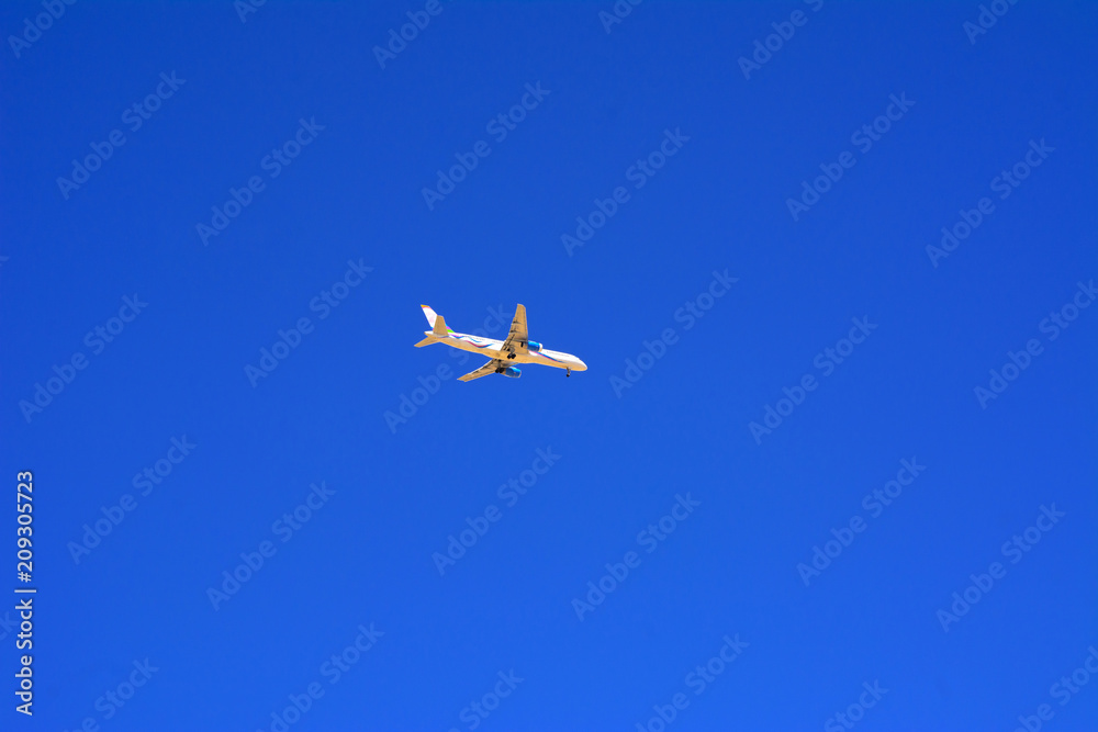 A large passenger plane flies high in the blue sky. Vacation, tr A large passenger plane flies high in the blue sky. Vacation, tr