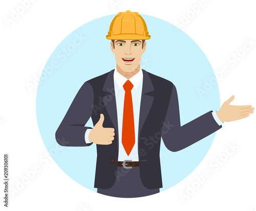 Businessman in construction helmet showing thumb up and showing something