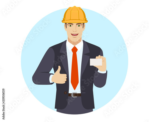 Businessman in construction helmet showing thumb up and showing the business card