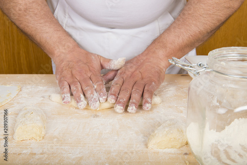 Cocinero amasando a mano una masa de harina para cocinar pasta o pan