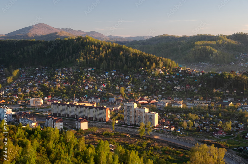 Green mountain landscape with illuminated sunset light town village valley among hills