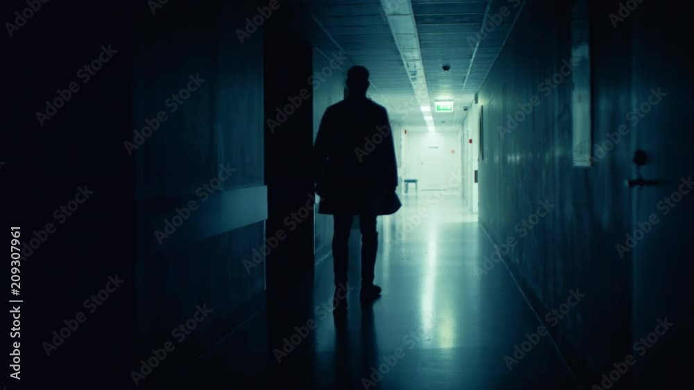 Medical Doctor in the Hospital Walks out of the Dark Corridor into the Light. Shot on RED EPIC-W 8K Helium Cinema Camera. Medical Doctor in the Hospital Walks out of the Dark Corridor into the Light. Shot on RED EPIC-W 8K Helium Cinema Camera.