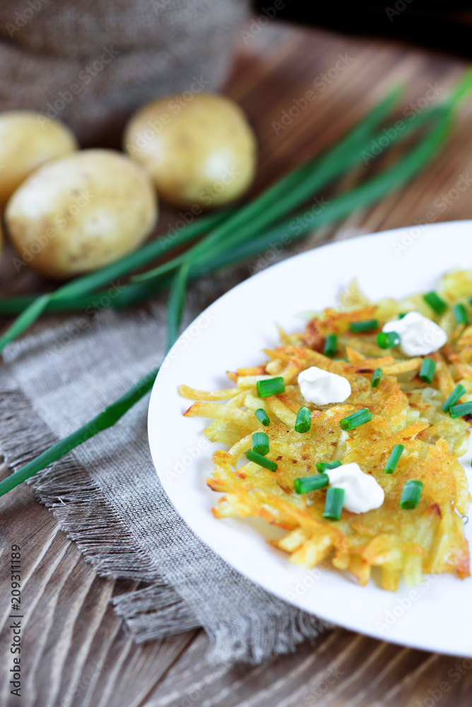 Fried potato pancakes or draniki with sour cream and green onion. The national dish of Belarus, Ukraine and Russia. Fried potato pancakes or draniki with sour cream and green onion. The national dish of Belarus, Ukraine and Russia.