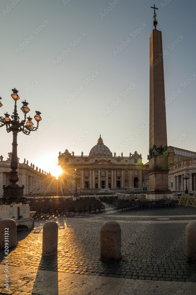 Tourists in St. Peter's Square, Vatican City (a city-state surrounded by Rome). Photo was taken at sunset