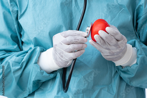 Doctor holding red heart shape model in hand, Medical heart care concept.