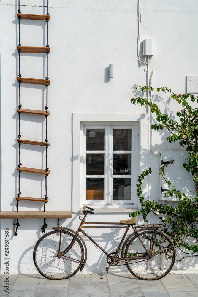 Old bike in front of white wall of hipster coffee store - Santorini Greece