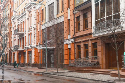 classic and modern orange houses in a winter street with puddles