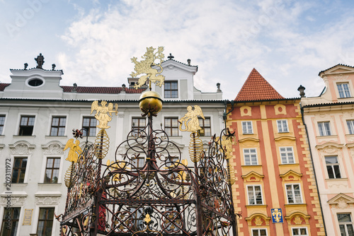 Prague, Czech Republic, Little Square - Decorations and railings of a well, against the backdrop of typical Prague buildings