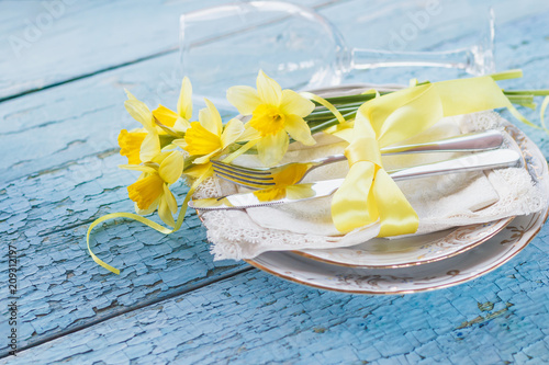 Fototapeta Naklejka Na Ścianę i Meble -  Set of tableware and a bouquet of yellow narcissus