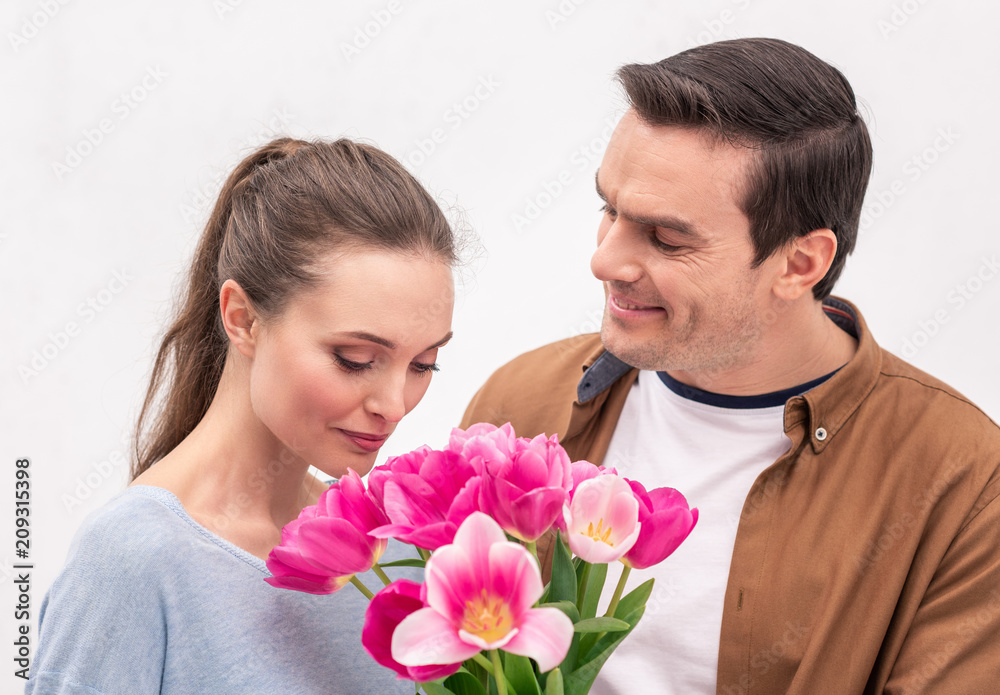 happy adult man presenting tulips bouquet for wife happy adult man presenting tulips bouquet for wife