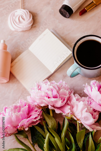 Beauty flat lay with a diary  cup of coffee  accessories and peonies on a marble background