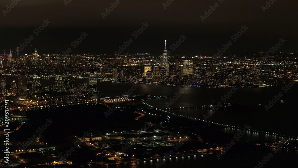 AERIAL: Stunning shimmering New Jersey and Downtown Manhattan skyline at night