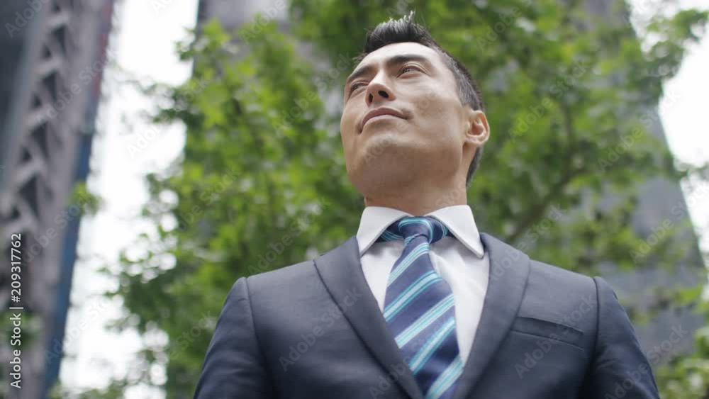 Portrait of successful asian business man looking to camera in the city, in slow motion Portrait of successful asian business man looking to camera in the city, in slow motion
