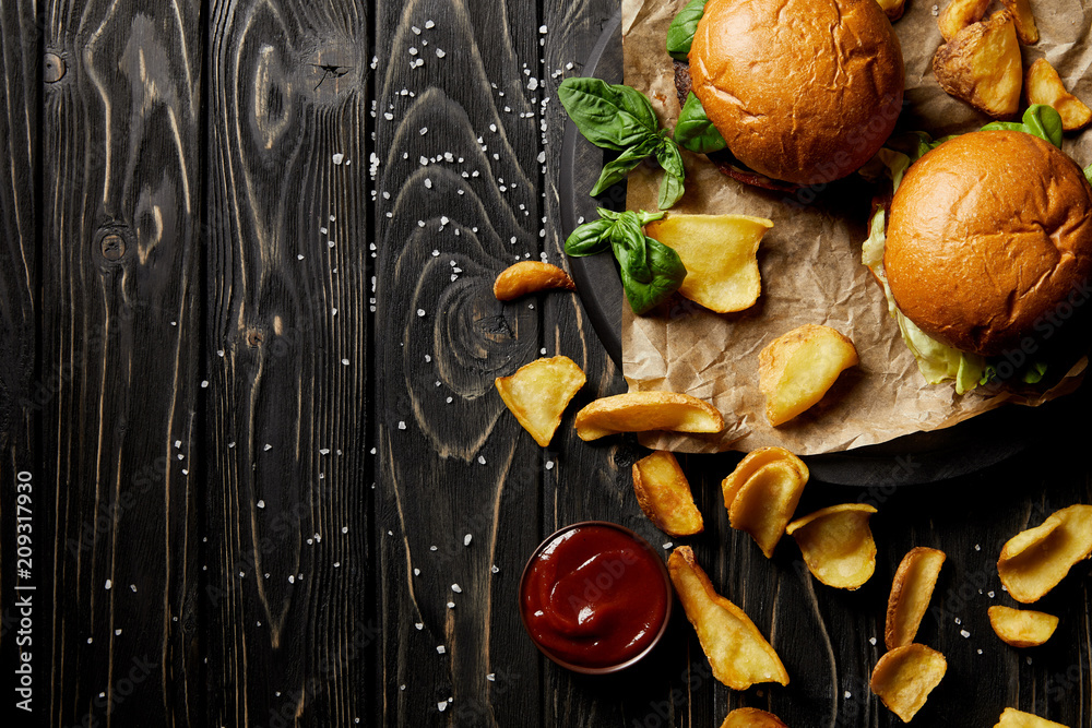 Top view composition of set of junk food diner with burgers and potato on table Top view composition of set of junk food diner with burgers and potato on table
