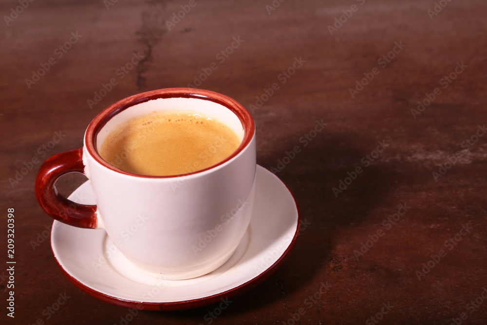A cup of espresso coffee on a dark wooden background A cup of espresso coffee on a dark wooden background