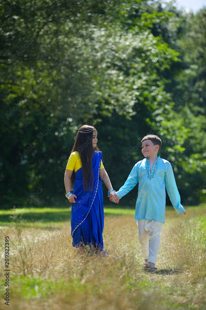 A lot of small children, boys and girls, dressed in the clothing culture of India.