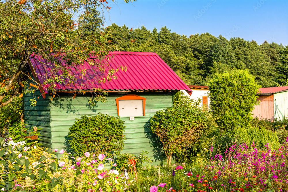 Summer house in the garden with flowers. Rural cottage in countryside. Summer house in the garden with flowers. Rural cottage in countryside.