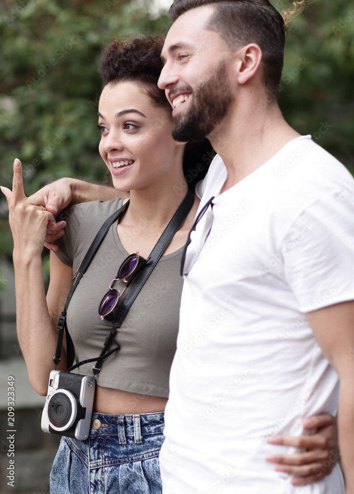 Naklejka premium Cheerful young couple walking on urban street