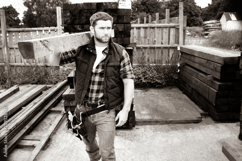 Lumber yard worker, carpenter, choosing, seclecting carrying timber planks