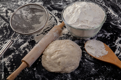 Stages of Making Bread-Flour, Dough and Loaf of Bread on Black Background