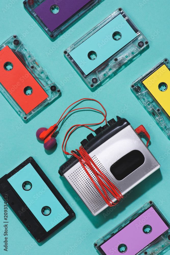 flat lay with colorful retro audio cassettes, cassette player and earphones isolated on blue flat lay with colorful retro audio cassettes, cassette player and earphones isolated on blue