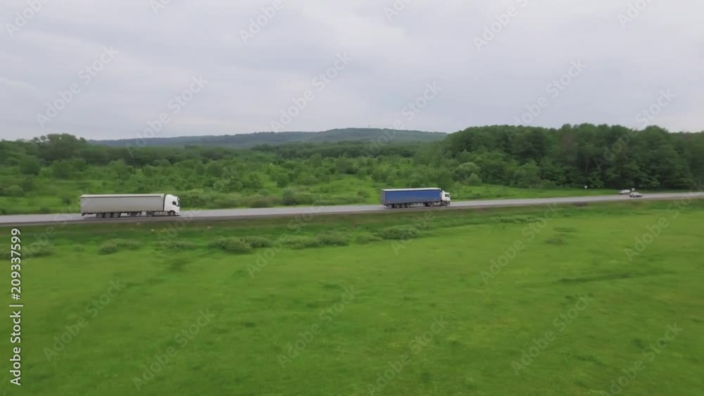 Trucks driving / traveling on the forest asphalt road aerial footage / top view / Highway truck traffic Trucks driving / traveling on the forest asphalt road aerial footage / top view / Highway truck traffic