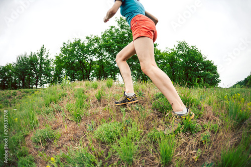 The girl is running on rough terrain.