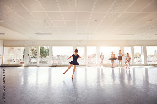 Little girl dancing ballet while group watching © Flamingo Images